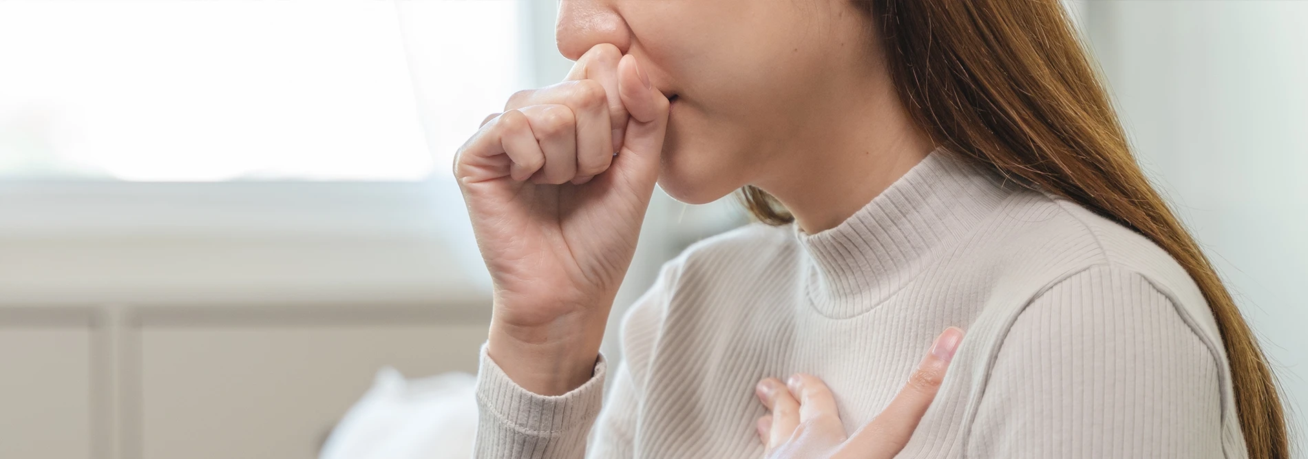woman with one hand on chest and holding the other hand to her mouth