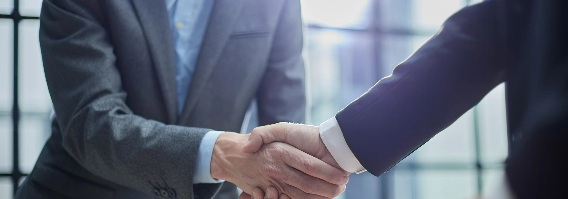 Two people in suits shaking hands